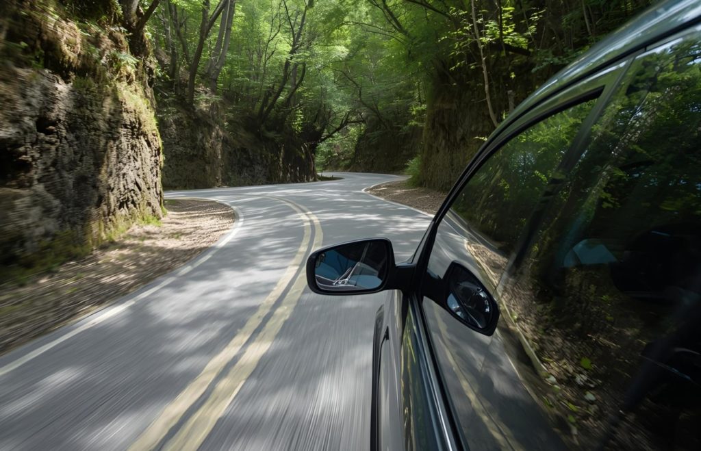 道路を走る車の写真。東京なら免許は必須でない。